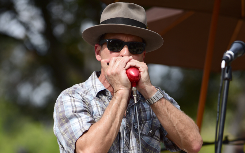Billy Watson playing a red harmonica